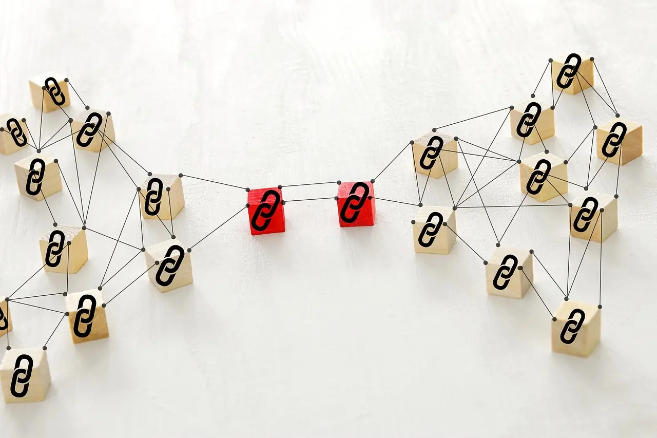 Wooden tags joined by lengths of string, two of them marked in red, standing in for a network of links