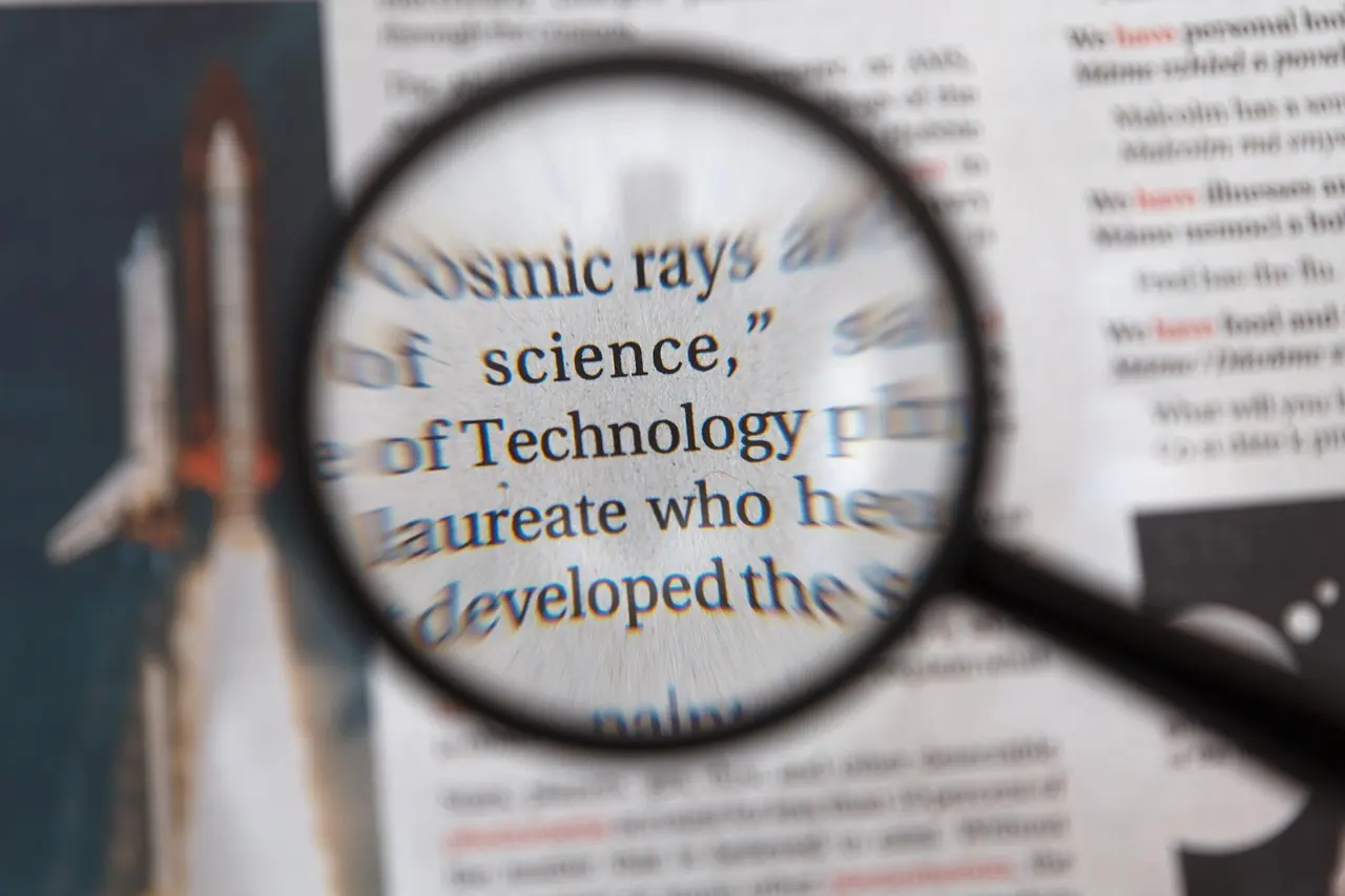 A magnifying glass enlarging a line of newspaper text